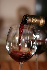 Du vin rouge est servi dans un verre