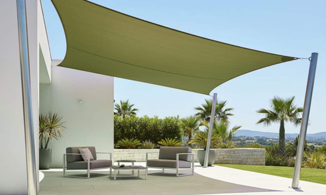 villa avec un voile d'ombrage vert étendu sur le côté de la maison pour fournir de l'ombre